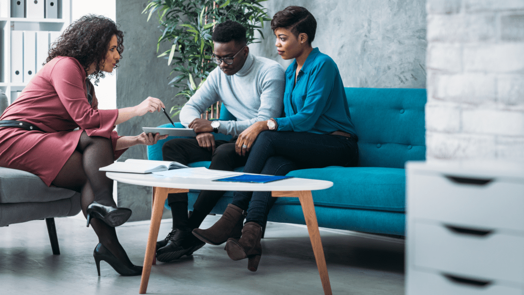 Financial Planner, man and a woman review documents on a sofa office setting