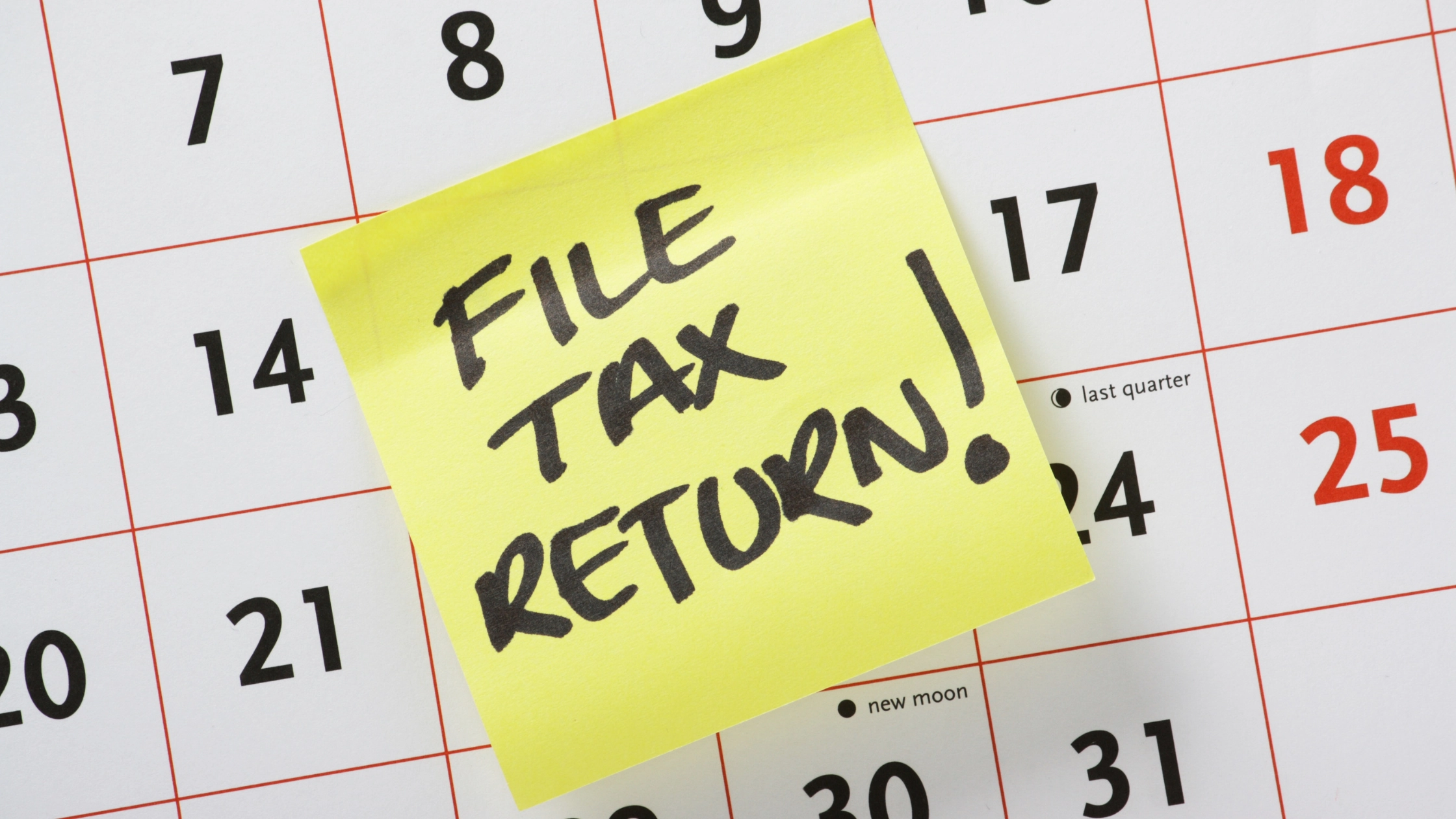 Calendar month of June with yellow sticky note reminder that says "file tax return!"